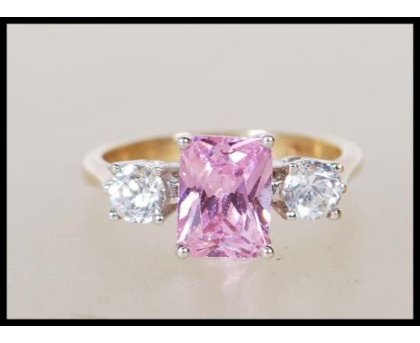 A hallmarked 9ct yellow gold ladies dress ring having central square cut pink stone flanked by two round cut CZ's. Marks for 