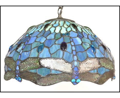 A vintage 20th Century Tiffany style leaded glass hanging ceiling light shade in blue and green decorated with dragonflies to