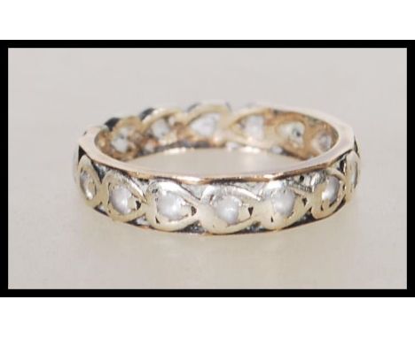 A 20th Century 9ct two tone eternity ring being set with white stones. Unmarked but tests as 9ct gold. Weight 2.2g. Size K.