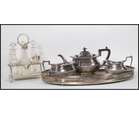 An early 20th Century three piece silver plated tea service set to a gallery twin handled silver plated serving tray together