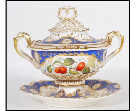 A 19th Century English Regency lidded ceramic twin handled tureen having detailed floral gilt work above sectional cobalt blu