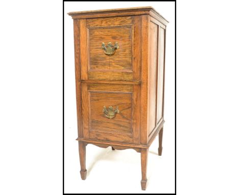 A vintage 20th Century oak two drawer filing cabinet, flared top over two deep panel drawers fitted with brass swag handles r