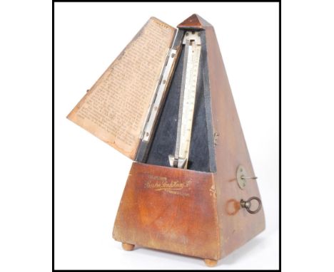 A vintage 20th Century Triangular cased wooden metronome with applied brass mounts Metronome by Maelzel, raised on three bun 