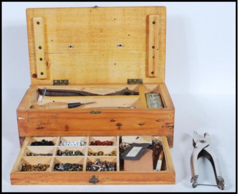 A vintage 20th Century pine case with leather carry handle to the top, lift up top revealing a collection of leather working 