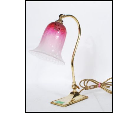 A vintage mid 20th Century brass adjustable swan neck desk lamp raised on a rectangular base with a frosted pink glass shade 