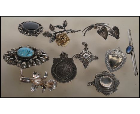 A collection of vintage silver and silver white metal brooches to include a stamped silver rose brooch, a stamped silver leaf