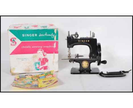 A vintage boxed Child's Singer Sewing machine model No. 20. Appears complete in box with instructions. Measures 17cm tall by 