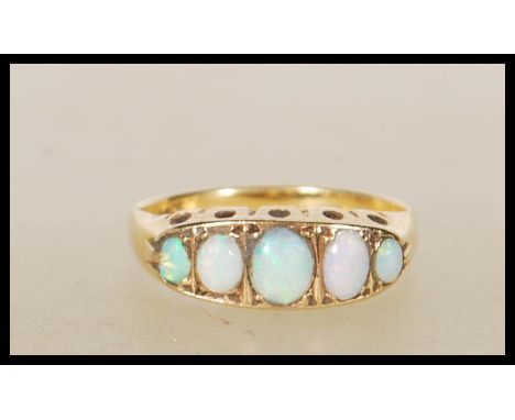 A 20th Century stamped 18ct gold ring set with five graduating oval opal cabochons. Weight 2.4g. Size K.5.