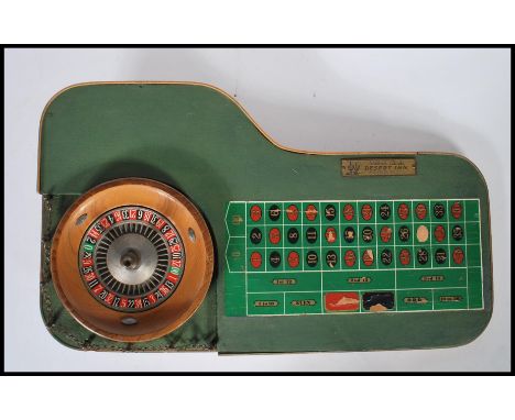 A vintage 1960's casino miniature roulette table having a spinning wheel and counter board with a plaque to the top reading W