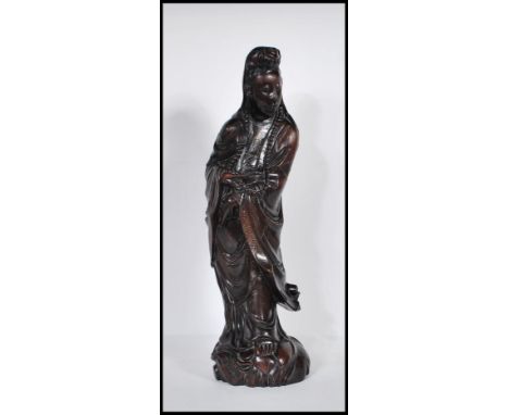 A 20th Century carved hardwood Chinese Kwan Yin figure having silver inlaid decoration, depicted wearing a string of beads. M