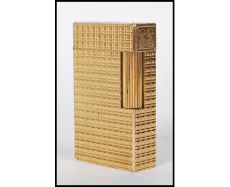 A gilt metal vintage 20th Century lighter by Dupont, the rectangular lighter with machine turned decoration and flip top lid,