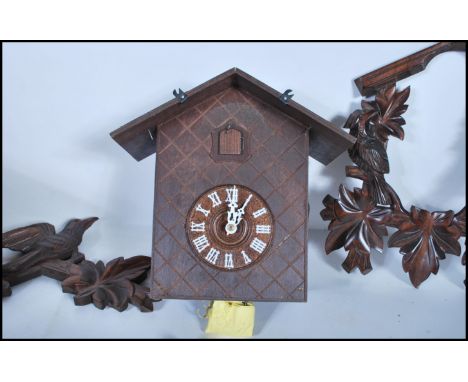 A mid-20th century black forest style wall cuckoo clock. Carved wooden surround, with deer and bird motif to top. Complete wi