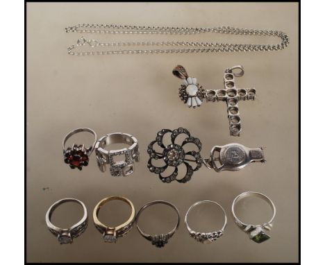 A collection of silver jewellery to include seven rings of differing designs including a red stone flower head ring, a green 