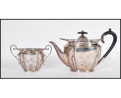 An early 20th Century Edwardian silver hallmarked part tea service, the teapot with ebonised handle and finial to the scroll&