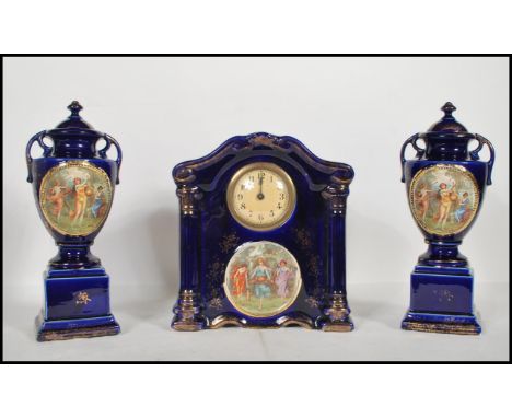 A early 20th Century English ceramic clock and garniture set by Empire ware. The central dial inset to decorative&nbsp;porcel