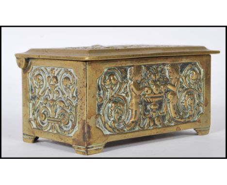 A early 20th Century brass trinket / cigarette box having foliate and swirl&nbsp;relief decoration with figures to front, ver