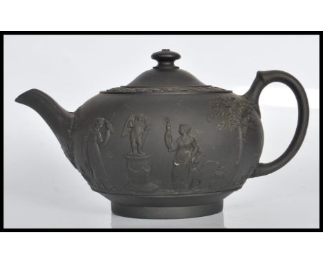 A 19th Century Victorian Wedgwood Jasperware&nbsp;black basalt teapot and cover having&nbsp;relief decorated figures and cher