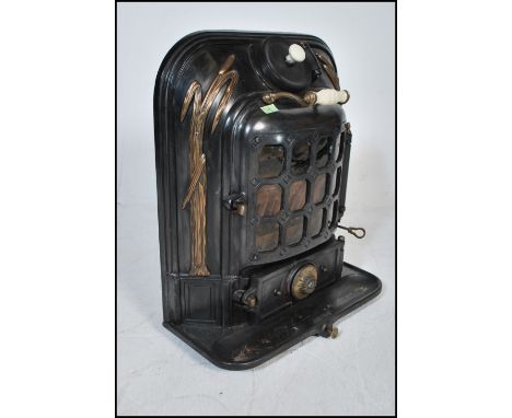 An early 20th Century antique La Salamandre stove having gilt reed decoration with a paneled glass paned door, having ceramic