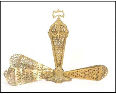 An early 20th century peacock fan fireguard screen having fold out brass fan sections with pierced decoration and carrying ha