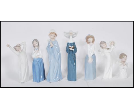 A collection of Nao and Lladro ceramic figurines to include a Lladro nun, a Lladro praying cherub, along with Nao figures to 