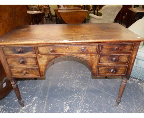 A REGENCY MAHOGANY WRITING TABLE, THE RECTANGULAR TOP OVER A CONFIGURATION OF SEVEN DRAWERS, CENTRAL ARCH AND TURNED CYLINDRI