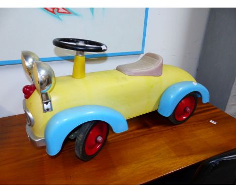 A VINTAGE STYLE TIN PLATE CHILD'S RIDE-ON TOY CAR WITH EYE HEADLAMPS.   L.74cms.