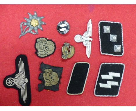 A SMALL COLLECTION OF SS INSIGNIA TO INCLUDE RANK AND CAP INSIGNIA IN METAL AND CLOTH, METAL EDELWEISS AND ENAMEL BADGE. (9)