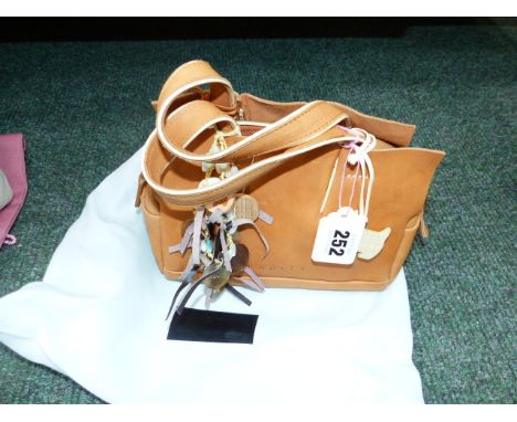 A RADLEY SMALL GRAB BAG IN LIGHT TAN LEATHER WITH TWO CHARMS AND DUST COVER.  