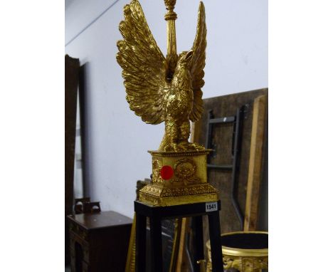 A CLASSICAL TASTE GILT AND EBONISED STANDARD LAMP, THE SPREAD EAGLE TOP ON FOUR FLARING SQUARE SECTIONED LEGS ENDING IN PAW F