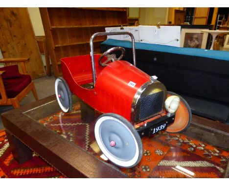 A VINTAGE STYLE RED PAINTED TIN PLATE PEDAL CAR.   L.83cms.