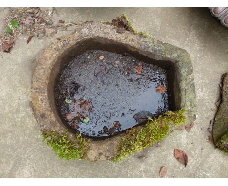 AN ANTIQUE HORSESHOE SHAPED STONE TROUGH.