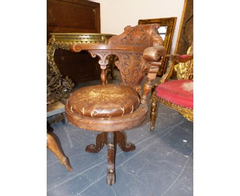 AN ANTIQUE OAK SWIVEL CAPTAINS CHAIR, THE BACK CARVED WITH FOLIAGE, THE CIRCULAR DROP IN CUSHIONED SEAT ABOVE IRON TRIPOD WIT