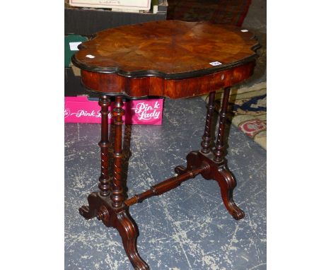 A ROSEWOOD WORK TABLE, THE EBONISED EDGED SHAPED OVAL LID OPENING ONTO COMPARTMENTS, THE TWIN COLUMN SUPPORTS ON PAIRS OF BRA