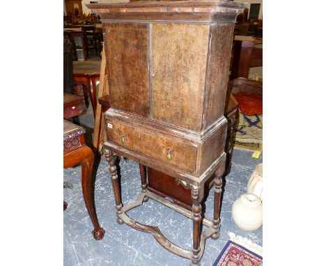 AN 18th.C.AND LATER OAK AND BURRWOOD CABINET ON STAND THE TWO DOOR UPPER SECTION ENCLOSING FITTED DRAWERS OVER A DEEP SINGLE 