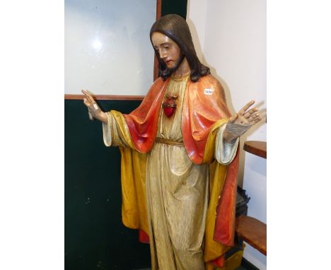 A PAINTED CARVED WOOD FIGURE OF JESUS, HIS HANDS RAISED IN BLESSING, A SACRED HEART ON THE CHEST OF HIS GREY STRIPED CREAM RO