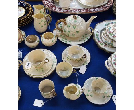 A collection of Belleek Shamrock teawares including teapot, cake plate, two jugs, two sugar bowls, trio with additional cup, 