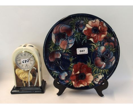 A Moorcroft Anemone pattern dish on blue ground, 26cm diameter, and an Old Tupton Ware mantel clock, decorated with Mackintos