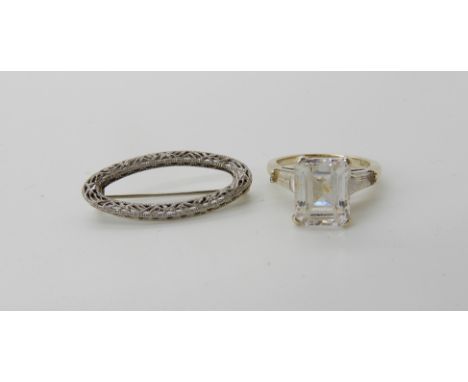 A 14k gold clear gem set ring, size K, with a 14k gold filigree brooch, weight combined 6.4gms Condition Report: Available up