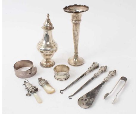 George V silver sugar caster, (London 1911), together with a silver spill vase, silver and mother of pearl babies rattle and 