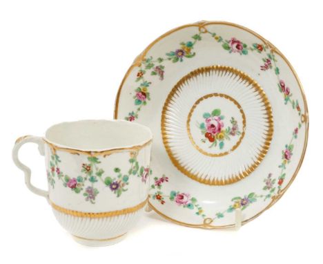 A Bristol coffee cup and saucer, circa 1775, part spirally fluted with scalloped rims, polychrome decorated with floral swags