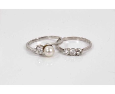 An antique diamond and cultured pearl two stone crossover ring with a 5.65mm cultured pearl and an old cut diamond on a plati