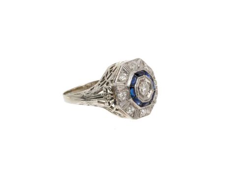 Art Deco diamond and sapphire cocktail ring with a central old cut diamond surrounded by a border of calibre cut synthetic bl