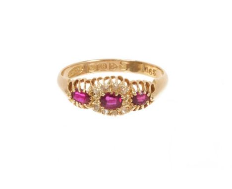 Edwardian ruby and diamond ring with a central ruby and diamond cluster flanked by two further rubies, all in claw setting on