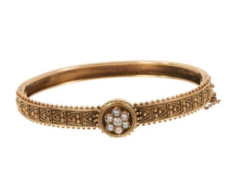 Victorian Etruscan Revival gold bangle with a central diamond and seed pearl cluster and applied filigree and beaded decorati