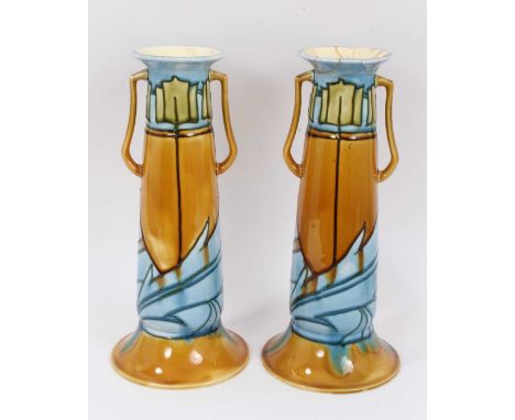 A pair of Minton Secessionist vases, of tapered form with two handles, decorated in blue and green tones with a foliate patte