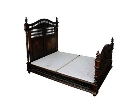 Ornate 19th century French carved chestnut double bed, with bobbin turned arched head and footboard centred by mask reserves,