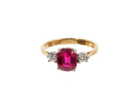 Diamond and synthetic ruby three stone ring epeith a central mixed cut synthetic ruby flanked by two round brilliant cut diam