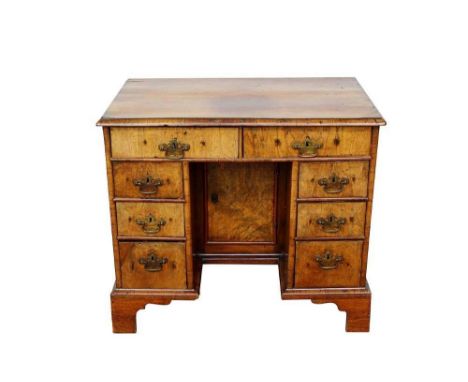 Early 18th century and later walnut desk, with eight drawers about the cupboard kneehole on bracket feet, 89cm wide x 57cm de