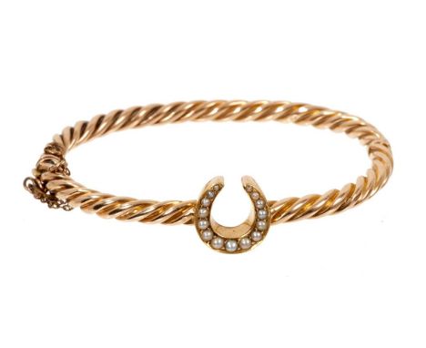 Victorian yellow metal rope twist hinged bangle with a central horseshoe set with seed pearls, 16.5cmBangle is unmarked. Weig