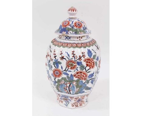 A 19th century Delftware vase and cover, of oval form with fluted body, polychrome painted in the Chinese style with flowers,